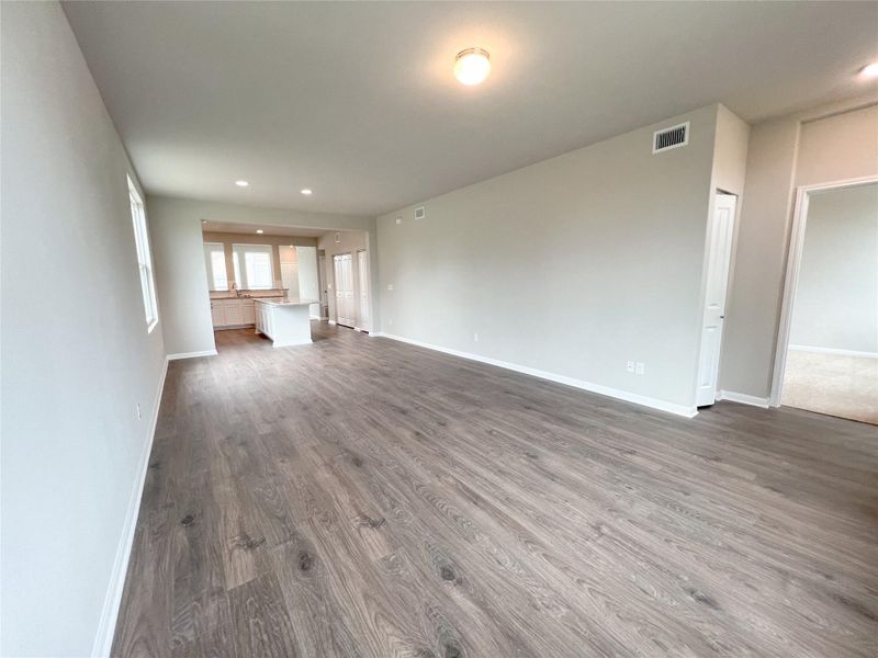 Unfurnished living room with dark wood-type flooring and recessed lighting