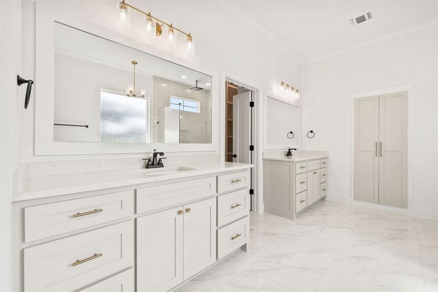Full bathroom with two vanities, a stall shower, and light marble finish floors Full bathroom with two vanities, a stall shower, and light marble finish floors