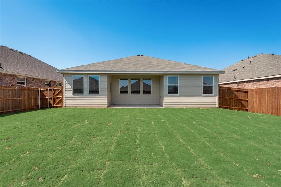 Rear view of property with a lawn and a patio area