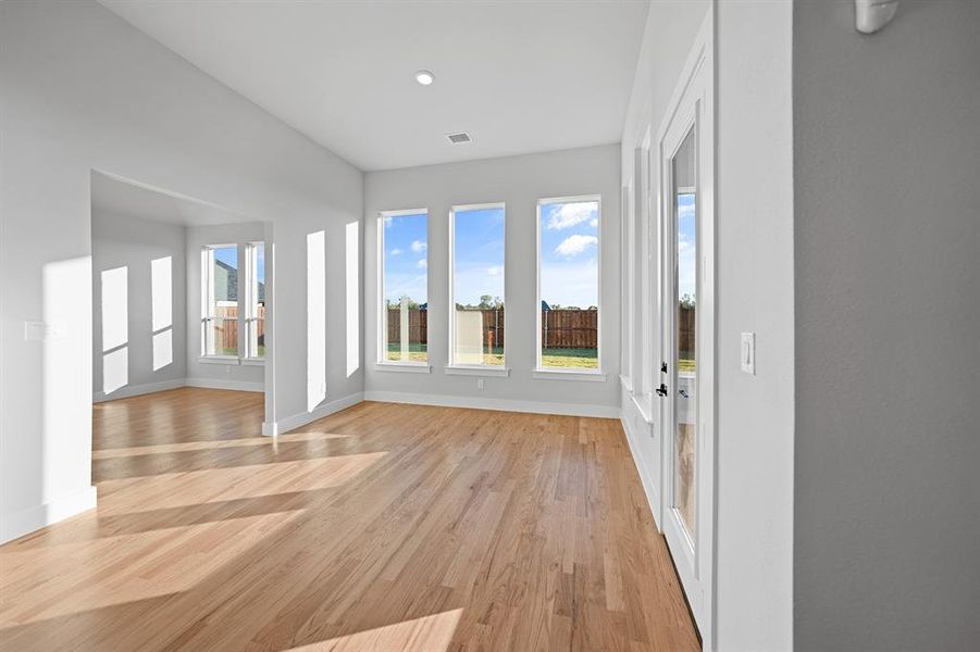 Unfurnished sunroom with wood finished floors and baseboards Unfurnished sunroom with wood finished floors and baseboards