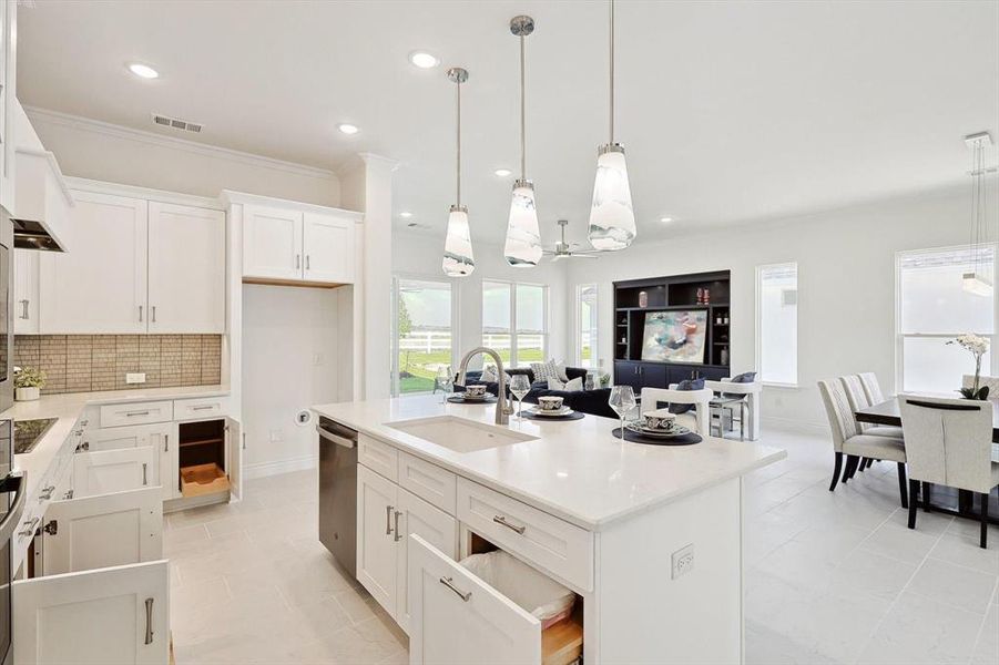 Kitchen featuring a center island with sink, sink, backsplash, and light tile floors