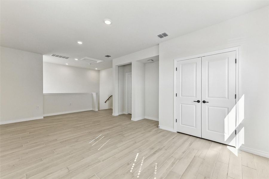 Below grade area featuring recessed lighting, light wood-style floors, baseboards, and visible vents Below grade area featuring recessed lighting, light wood-style floors, baseboards, and visible vents