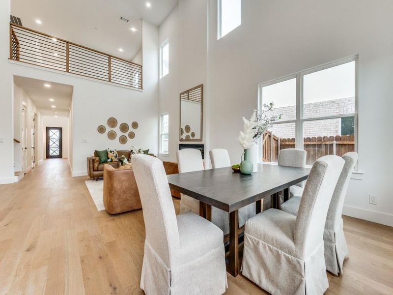 Dining room featuring a towering ceiling and light wood-type flooring