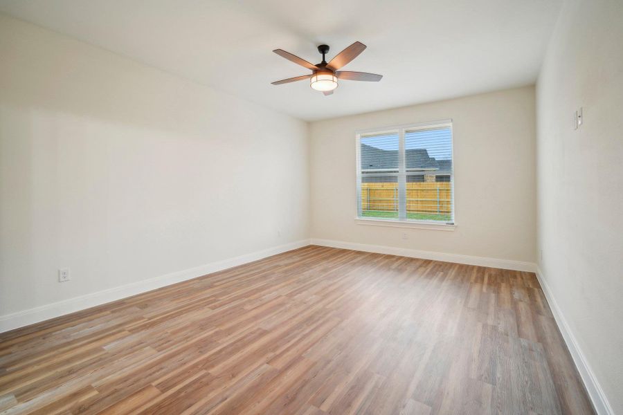 Primary Bedroom featuring a ceiling fan, baseboards, and light wood finished floors