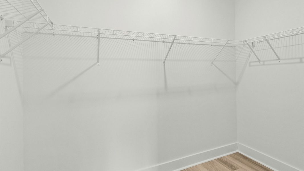 Spacious primary closet with built-in shelving at Chestnut Farms by DRB Homes