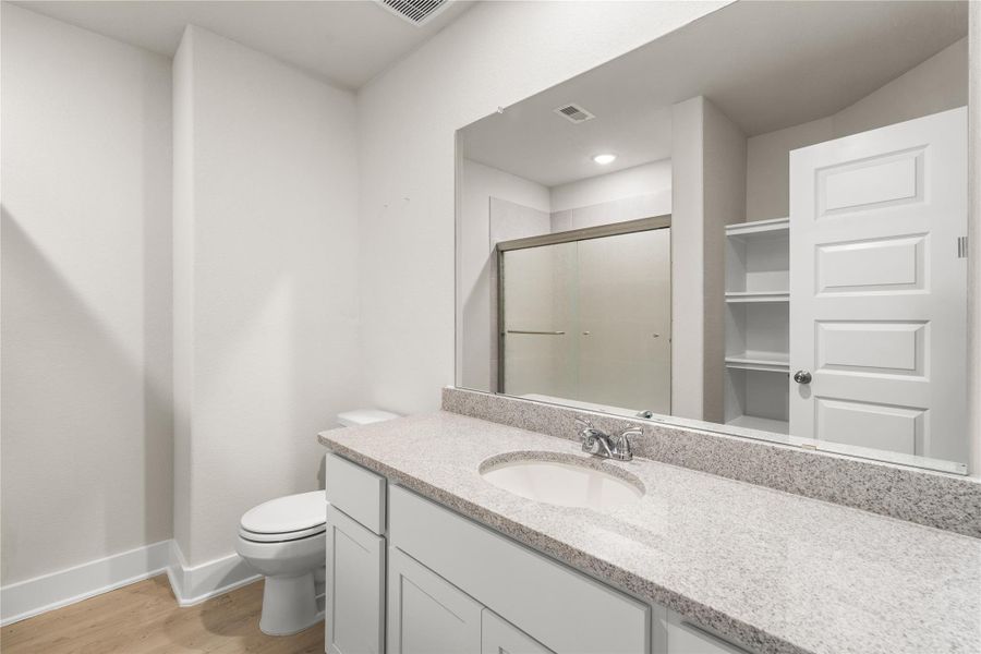 Designed to comfortably serve the secondary bedrooms, this full bath features generous counter space, built-in linen storage, and a layout that keeps daily routines running smoothly.