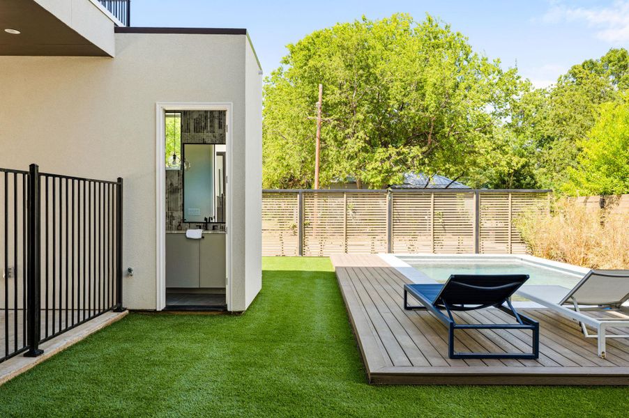 An inviting swimming pool and custom wood deck highlight this modern backyard oasis. An inviting swimming pool and custom wood deck highlight this modern backyard oasis.