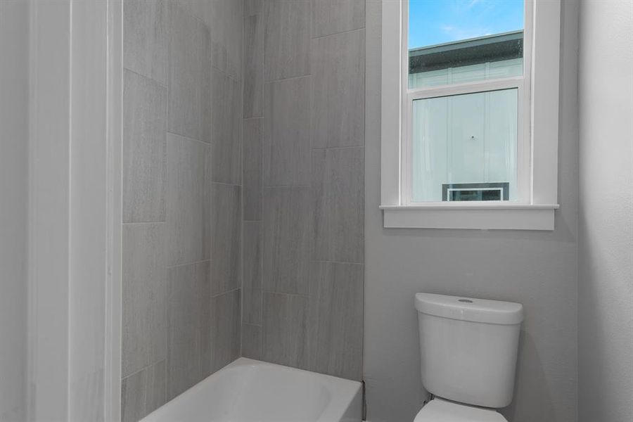 Bathroom featuring shower / bathing tub combination and toilet