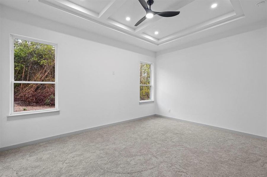 Spare room with beamed ceiling, ceiling fan, carpet floors, and coffered ceiling