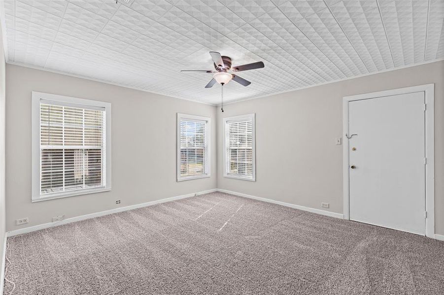 Carpeted spare room with baseboards and ceiling fan