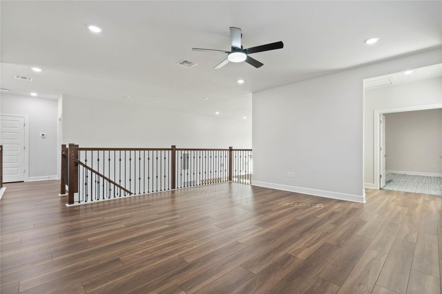 Rich wood floors and classic iron balusters define this versatile upstairs landing.