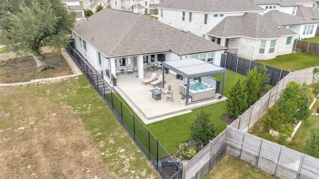 An aerial perspective showcases a spacious backyard patio completed with a sleek metal pergola.