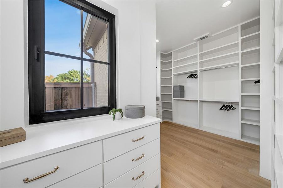 Custom closet system featuring extensive shelving, hanging rods, and built-in drawers with brass hardware
