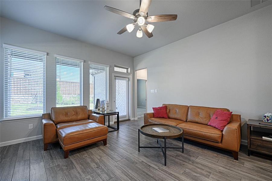 Living room with ceiling fan and hardwood / wood-style flooring