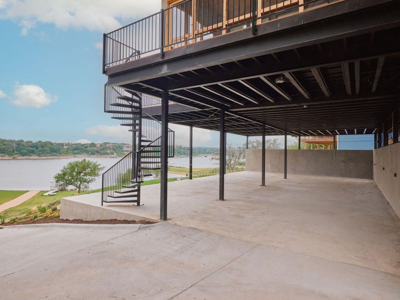 Covered ground-level parking area featuring concrete flooring and supportive metal beams