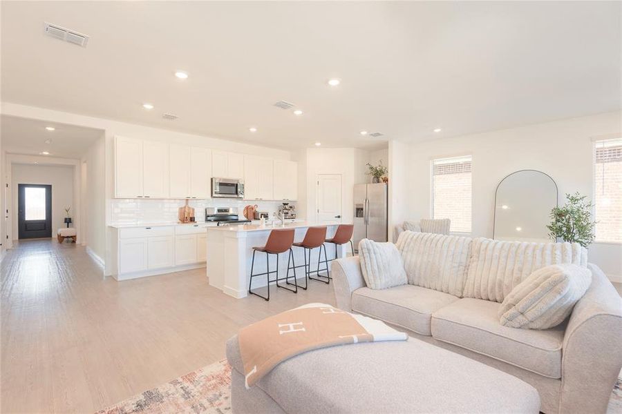Living room featuring light wood-style flooring and recessed lighting Living room featuring light wood-style flooring and recessed lighting