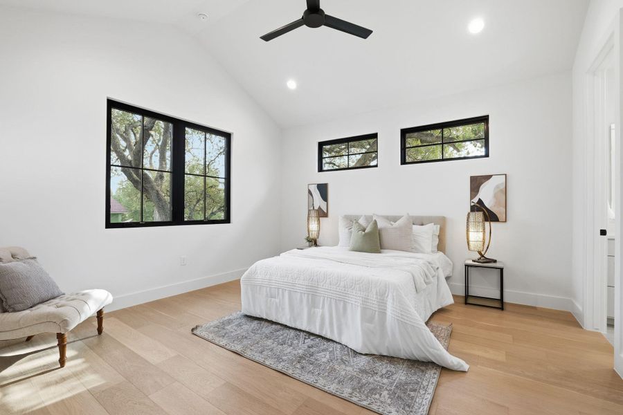 Bedroom with light wood-type flooring, recessed lighting, multiple windows, a ceiling fan, and vaulted ceiling