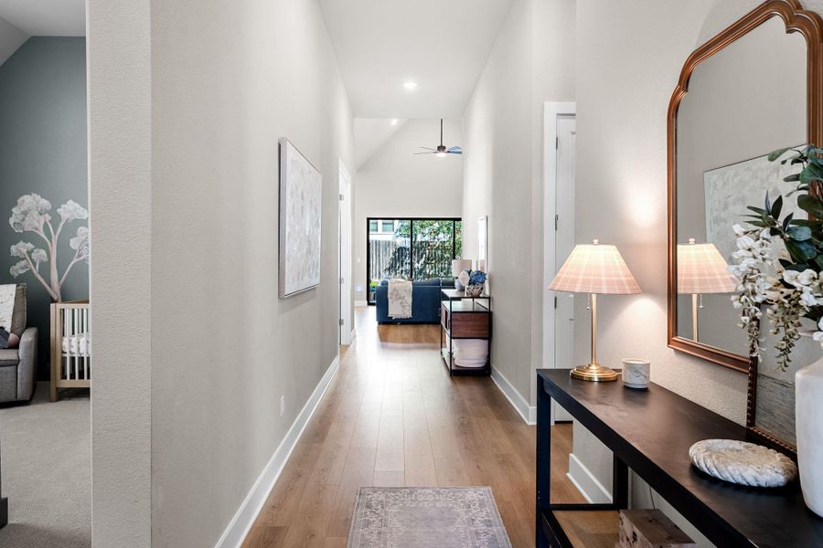 Hallway with wood-finish flooring, white baseboards, and light neutral walls