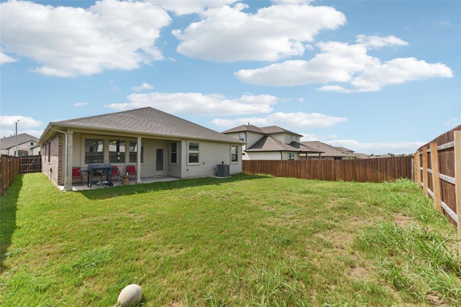 Back of house with a fenced backyard, roof with shingles, and a patio Back of house with a fenced backyard, roof with shingles, and a patio