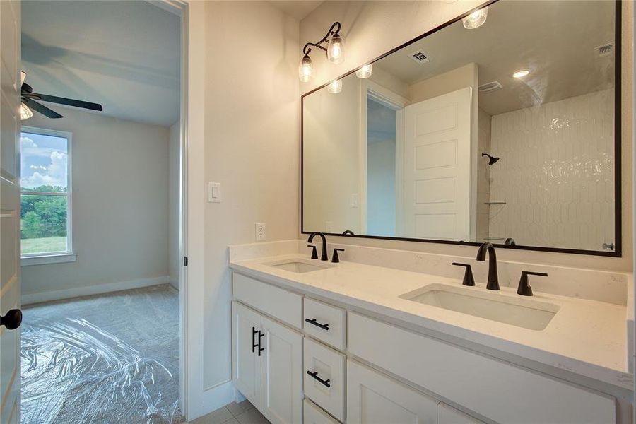 Bathroom featuring ceiling fan and dual bowl vanity