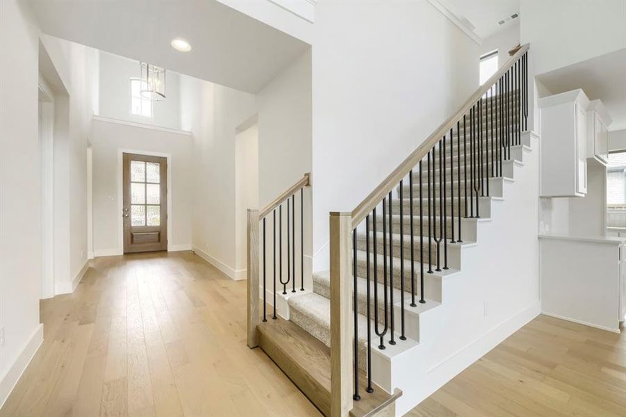 Staircase featuring a light wood-finish handrail and black iron balusters Staircase featuring a light wood-finish handrail and black iron balusters