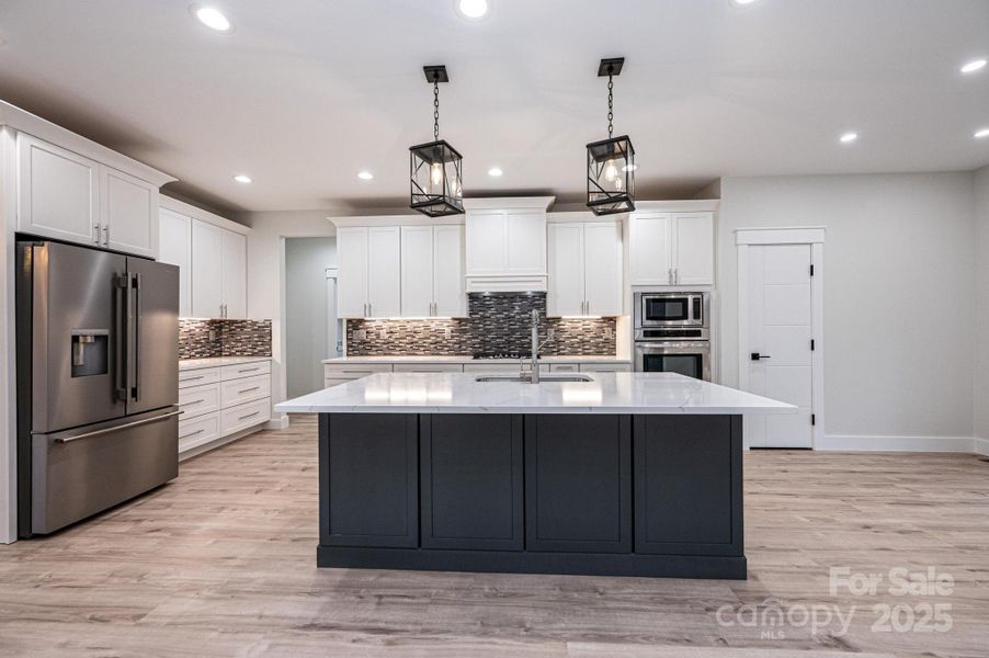 Kitchen is Open to the Great Room. Offers a large Island with a Breakfast Bar and Sink. Quartz Countertops, Tile Backsplash, Refrigerator, Gas top Range, Microwave, Oven and Dishwasher. Kitchen is Open to the Great Room. Offers a large Island with a Breakfast Bar and Sink. Quartz Countertops, Tile Backsplash, Refrigerator, Gas top Range, Microwave, Oven and Dishwasher.