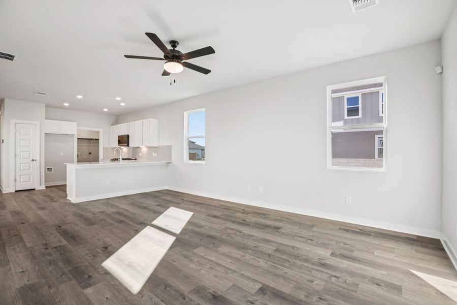 A room with a wood floor and a ceiling fan.
