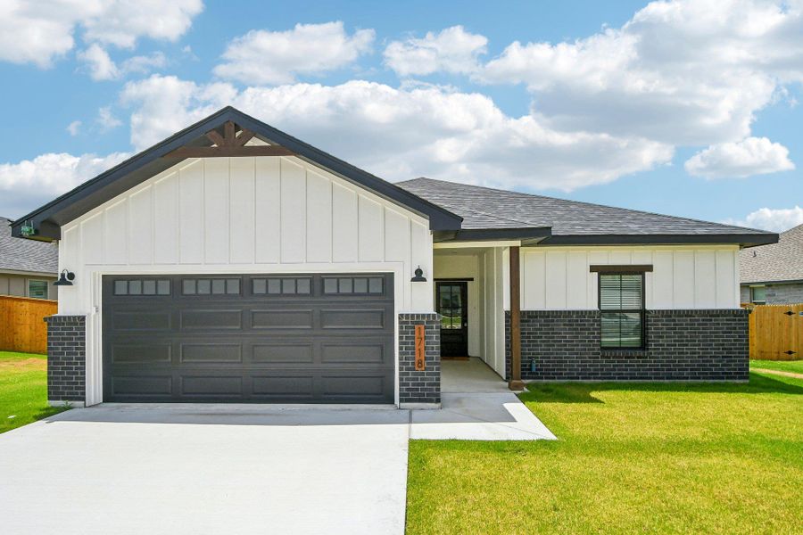 A modern facade with board and batten siding and dark brick accents welcomes you home. A modern facade with board and batten siding and dark brick accents welcomes you home.