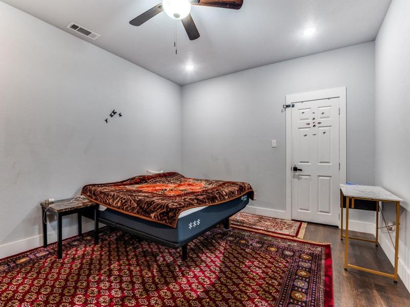 Bedroom with dark wood-style flooring and a ceiling fan Bedroom with dark wood-style flooring and a ceiling fan