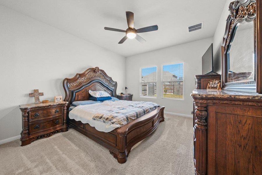 Bedroom featuring a ceiling fan and light colored carpet