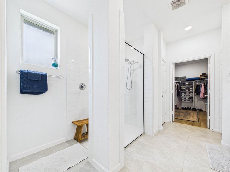 Truly a walk in shower! There is also a linen closet between the shower and primary walk-in closet.