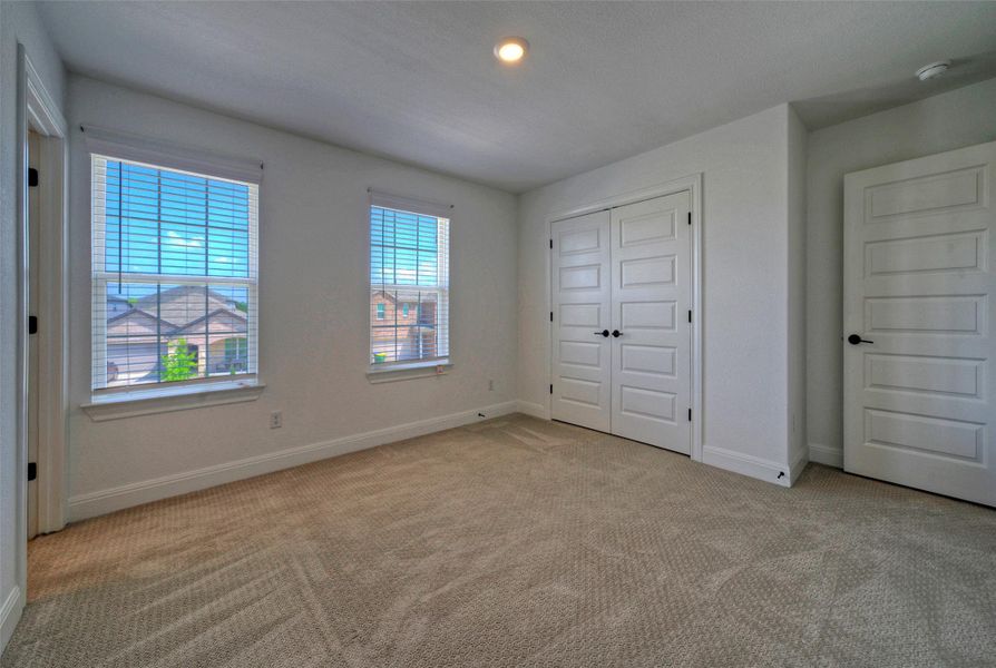 Double windows frame neighborhood views in a comfortable space featuring clean trim and soft carpeting. Double windows frame neighborhood views in a comfortable space featuring clean trim and soft carpeting.