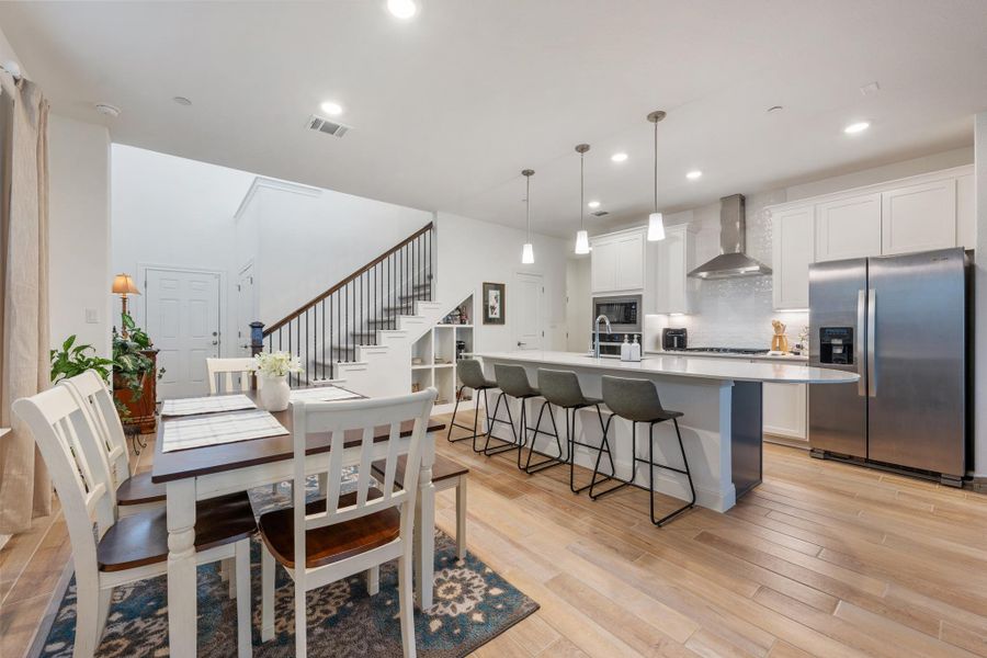 An open concept design, this space blends culinary artistry with comfortable dining and features a striking staircase. An open concept design, this space blends culinary artistry with comfortable dining and features a striking staircase.