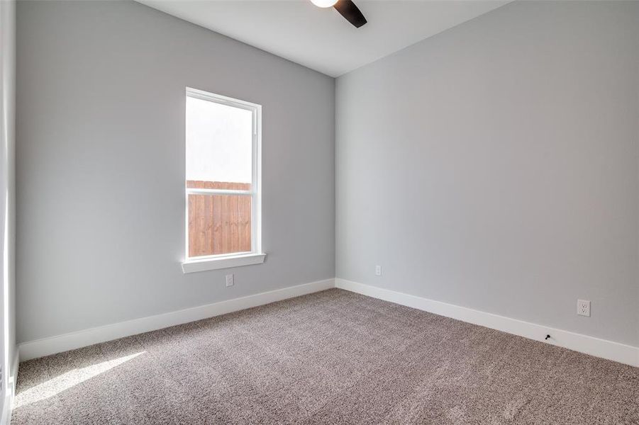 Unfurnished room featuring carpet and ceiling fan