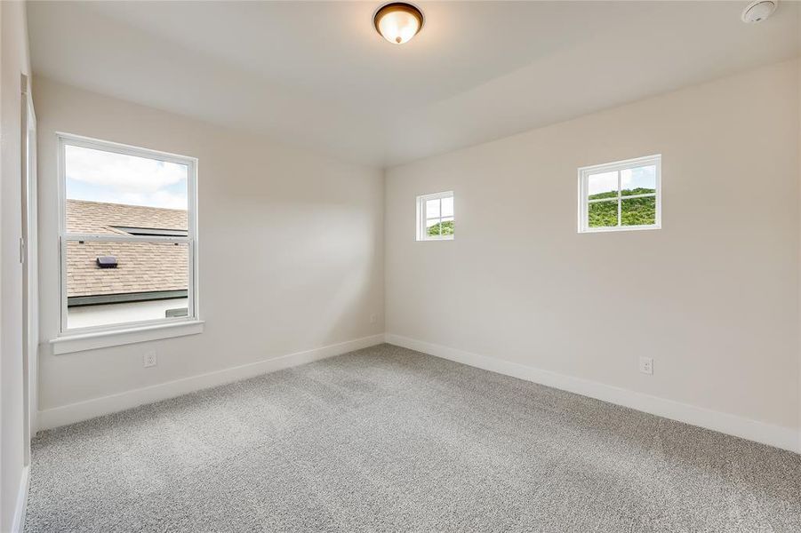 This secondary bedroom has 2 small fixed windows for interest and light.