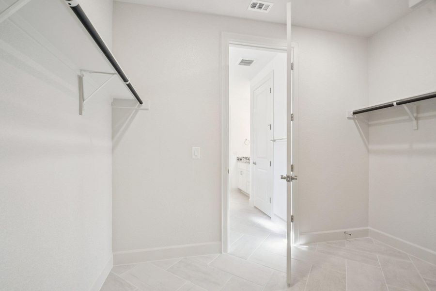 Walk in closet featuring light tile patterned flooring Walk in closet featuring light tile patterned flooring