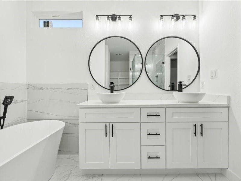 Bathroom with a tub to relax in, vanity, tile walls, and tile patterned flooring