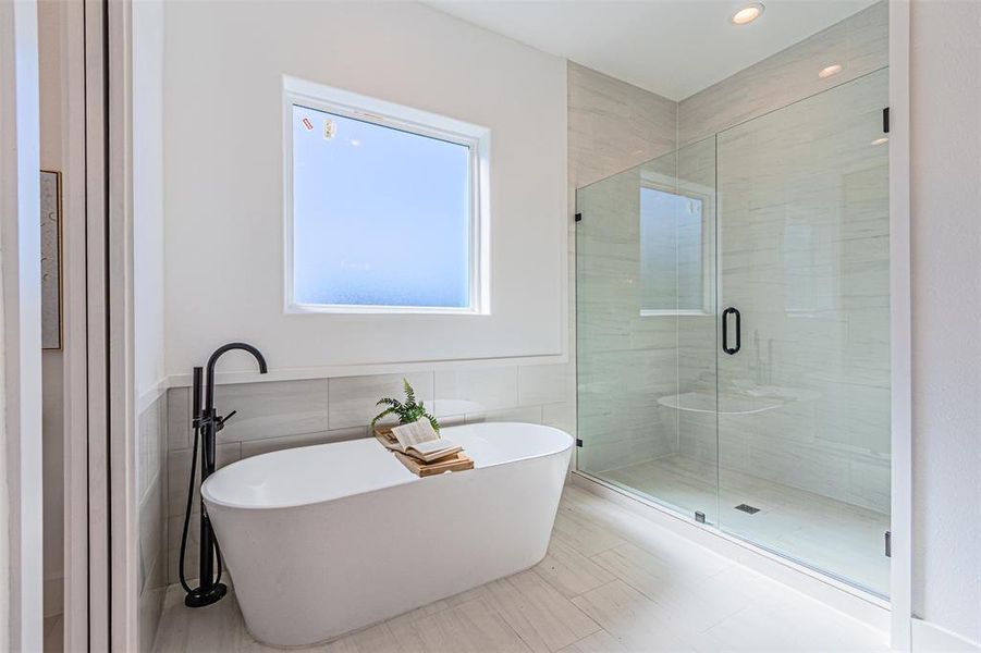 Full bathroom with tile walls, a freestanding bath, a shower stall, a wainscoted wall, and recessed lighting Full bathroom with tile walls, a freestanding bath, a shower stall, a wainscoted wall, and recessed lighting