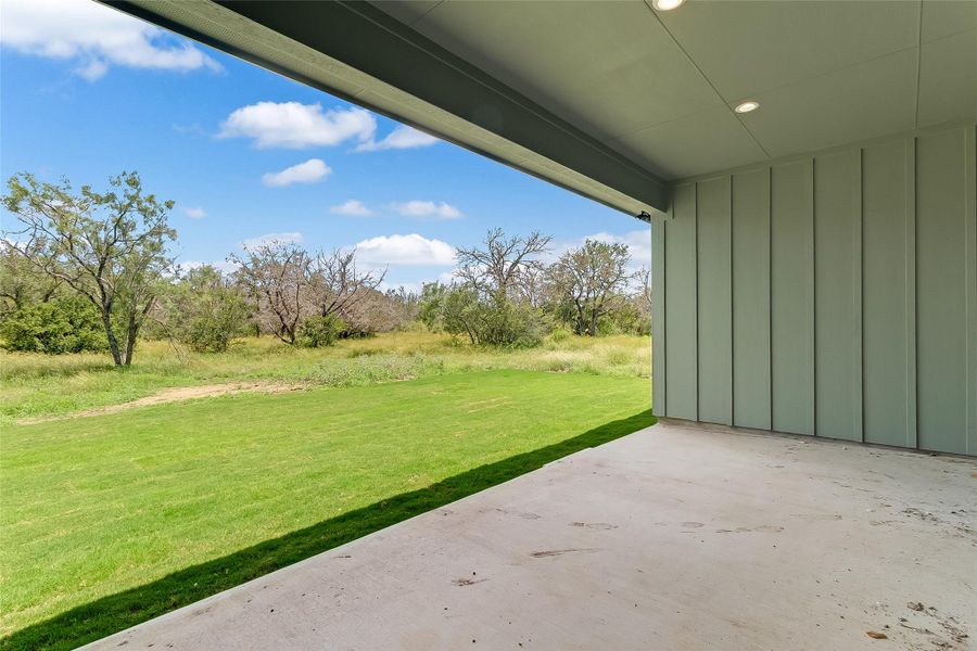 View of green lawn with a patio