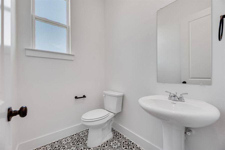 Half bath with baseboards and tile patterned flooring Half bath with baseboards and tile patterned flooring