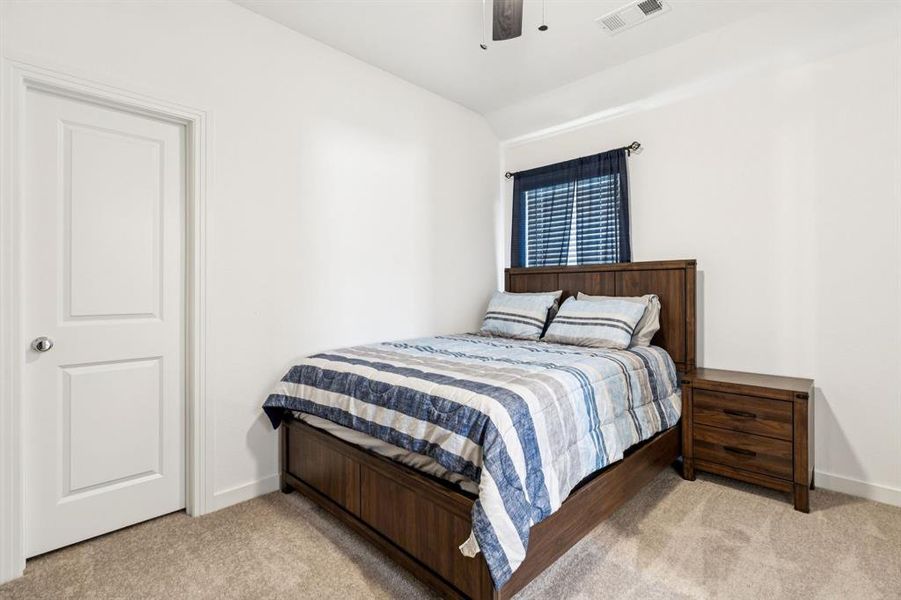 Bedroom with light colored carpet and a ceiling fan Bedroom with light colored carpet and a ceiling fan