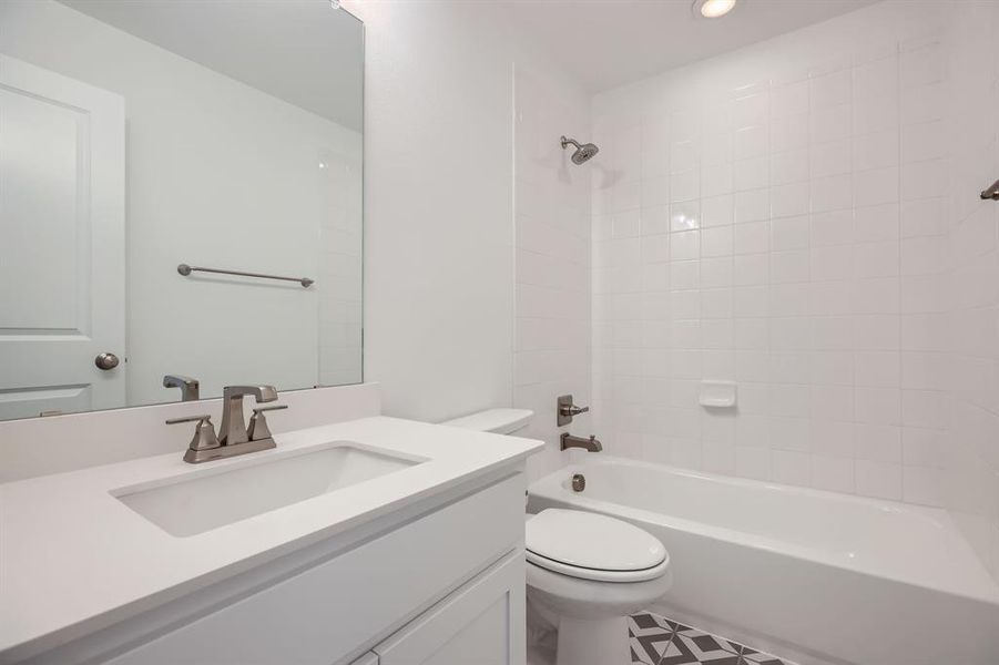 Bathroom with toilet, vanity,  shower combination, and recessed lighting