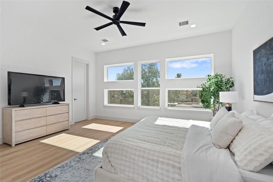 Another look at the primary suite, where sunlight pours through picture windows & a discreet door opens to the spacious walk-in closet. Another look at the primary suite, where sunlight pours through picture windows & a discreet door opens to the spacious walk-in closet.
