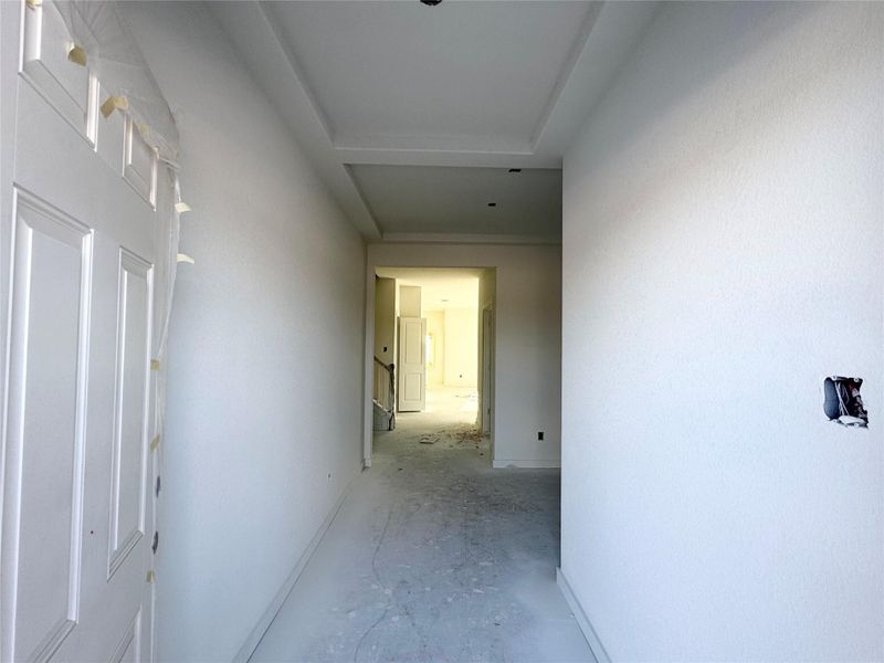 Hallway featuring concrete flooring and baseboards Hallway featuring concrete flooring and baseboards