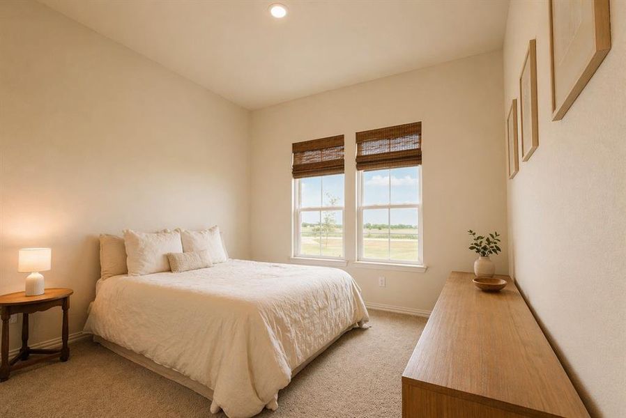 Bedroom featuring twin windows with woven shades, recessed lighting, and neutral-toned carpeting