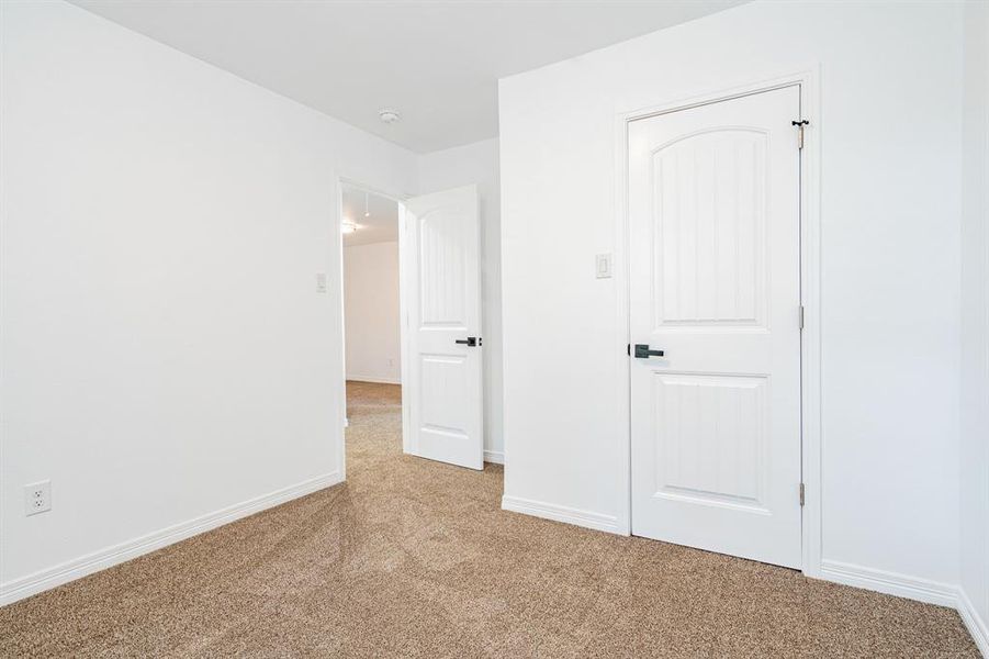 Unfurnished bedroom with light colored carpet and a closet