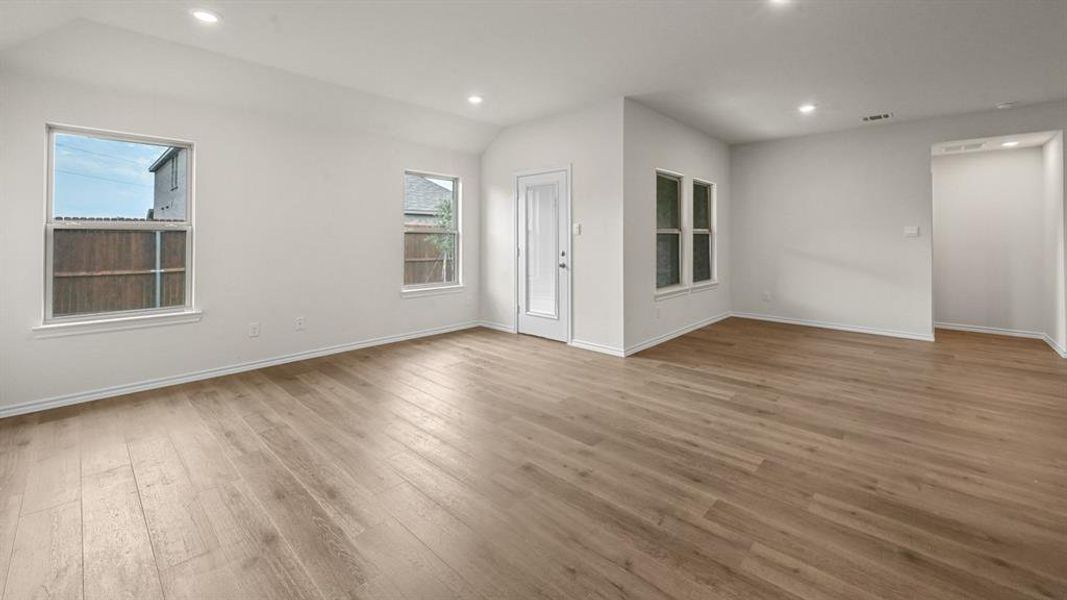 Empty room with recessed lighting, vaulted ceiling, and light wood-style floors