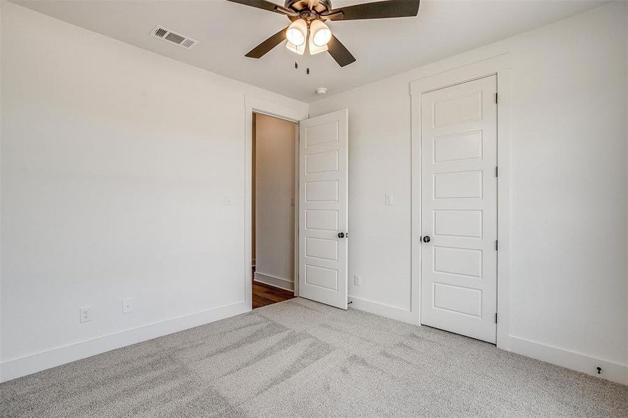 Unfurnished bedroom featuring carpet floors and ceiling fan