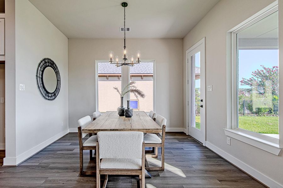 Bright dining area with large windows overlooking the backyard