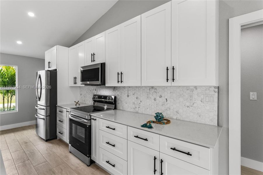 A commercial-style matte black pull-out faucet with pot filler functionality, undermount sink, and sleek finishes elevate both design and performance.